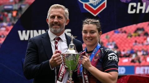 Wigan Warriors' women's head coach Denis Betts (left) hold the Challenge Cup trophy with Vicky Molyneux at Wembley