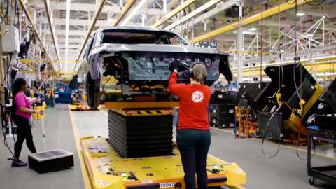 Autoworkers in a car factory