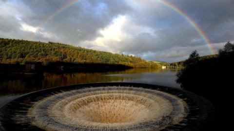 The Ladybower plug with a rainbow in the skies above