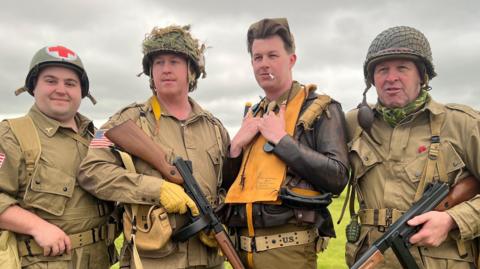 Four men dressed in US military uniforms from World War Two, Duxford