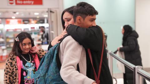Ahmad, 12, is greeted by his mum, Hafsa, after arriving at Terminal 3 of London Heathrow Airport from Pakistan via Dubai, where he spent three nights alone in Dubai airport, looked after by Emirates staff.