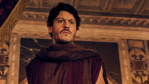 Iwan Rheon playing Tanex, dressed in ancient Roman clothes, in a scene from Those About To Die 