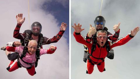 Jennifer Sephton (left) completes the skydive attached to an instructor. She has blonde hair and wears a pink t-shirt over a red jumpsuit. Adrian Antell cheers as he completes the jump attached to an instructor. He has short hair and wears a red jumpsuit.