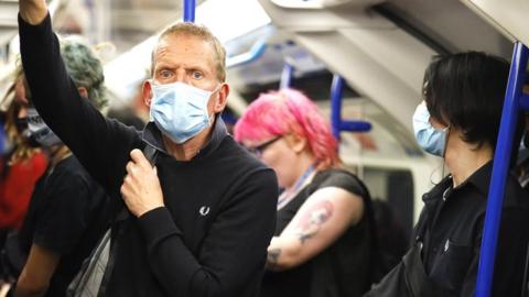 Man wearing a face mask on a London Underground train