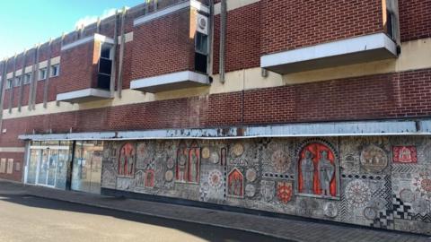 A stone mural on a derelict building