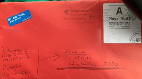 Letter sent mistakenly to Penarth, south Wales rather than Penrith, Australia. It is a red envelope with writing in biro with the air mail sticker and stamp visible in the top left and top right 