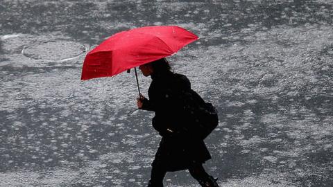 Woman walks in heavy rain