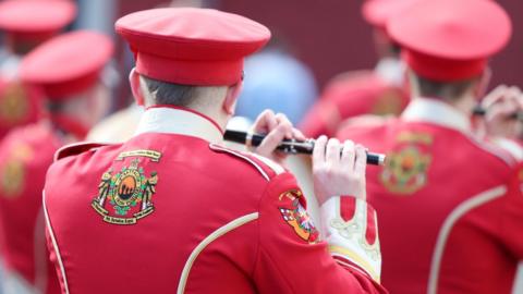 A bandsman plays a flute during a parade