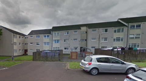 A row of flats with overcast skies above them