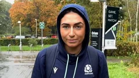 Emma Wassell, wearing a Scotland rugby hoodie, smiling at the camera