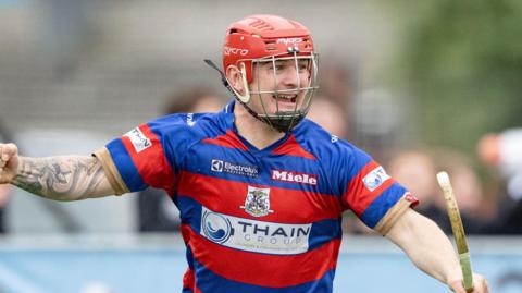 Kingussie shinty player celebrates scoring in the MacTavish Cup final 2025 in Inverness