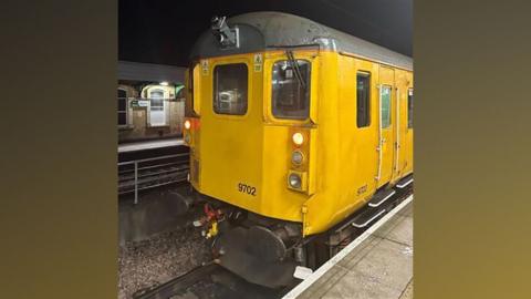 A yellow Network Rail train with a camera installed on the front