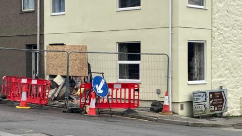 The scene of the crash in Redruth. A house can be seen with part of the wall damaged.