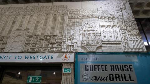 A large stone-effect mural in a shopping centre.