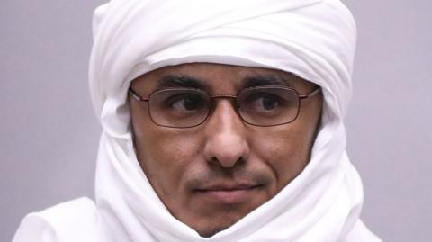 A close-up shot of Al-Hassan Ag Abdoul Aziz Ag Mohamed Ag Mahmoud, wearing glasses, at his 2019 trial at the International Criminal Court (ICC).