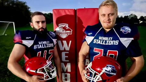 Lucasz Smolen [left] and Lachlan Cotter with American football helmets