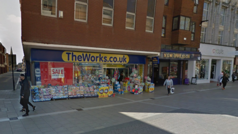 A parade of shops on a pedestrianised street - The Works, New Horizon and Yours