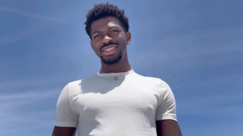 Lil Nas X pictured in a white t-shirt against a clear blue sky, in a screengrab from his Instagram statement