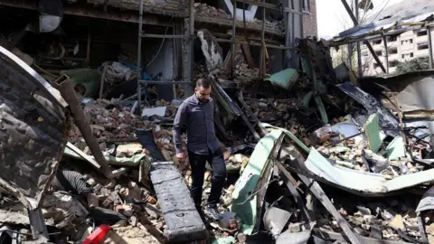 Iranian officials inspect the damage after US-Israeli airstrikes on the Shahid Beheshti University, in Tehran, Iran