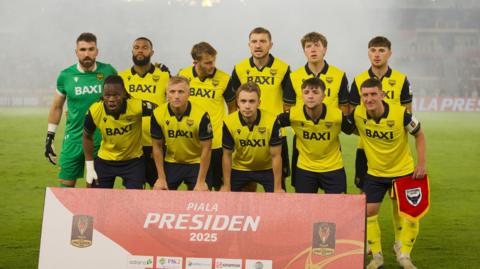 Oxford United players pose for a photo before their game in Jakarta