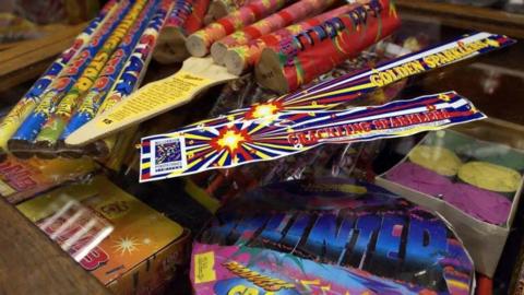 A cluster of fireworks and sparklers, in brightly coloured packaging.