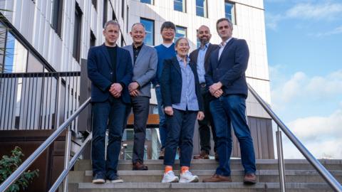 A group photo of the team behind the new Southampton Space Institute. Left to right: Prof Mark Sullivan, Prof David Parker, Prof Minkwan Kim, Frances Clarke, Prof Andrea Cammarano and Institute director Prof Matt Middleton. They are photographed on stairs outside, in front of a building. It is a clear day.