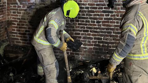 Two firefighters dealing with an embers fire in Langdon Hills, Essex