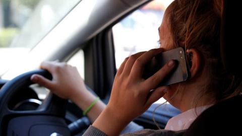 Woman using mobile phone while driving