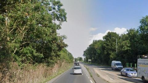 Google Street View of the A4 at Colnbrook - a two-way road full of cars and lined with trees