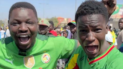 Senegalese fans earing jerseys shouting with joy