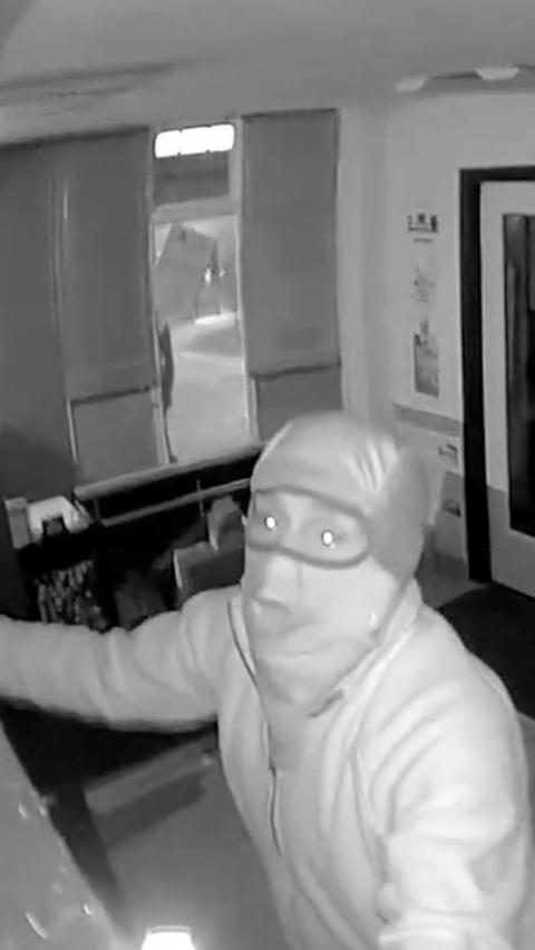 CCTV footage shows a man taking stock from a trading cards shop during raid