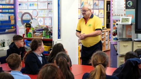 Gareth Jones yn siarad o flaen dosbarth o blant