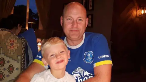 Dyn a bachgen yn gwenu