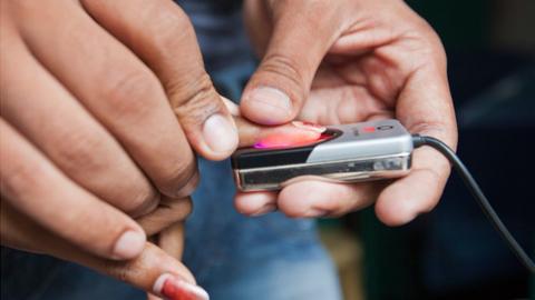 A biometric system being used to record fingerprints