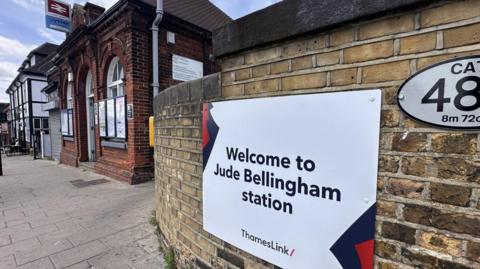 A white sign at Bellingham station reads "Welcome to Jude Bellingham station"