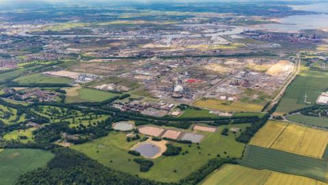 An overhead view of the Wilton International complex. There are many industrial plants surrounding by farming lands. 