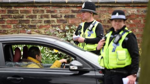 Police officers from North Yorkshire Police stop motorists in cars to check that their travel is "essential"