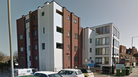 A five-storey block of flats - a brown and white brick building.