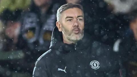 Ryan Dicker looks on from the dug out during a Crewe match