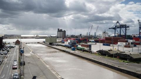 A view from the control tower at the Port of Immingham. It is a grey cloudy day and containers and cranes can be seen beyond the dock side.