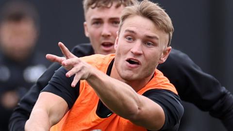 Harri Morgan gets the ball away in training