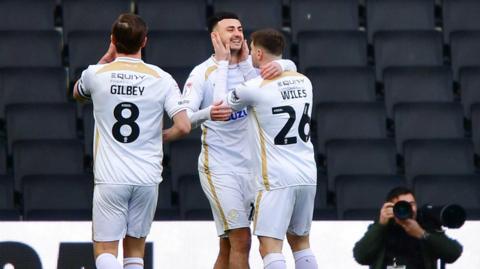 Aaron Collins of MK Dons (centre) celebrates