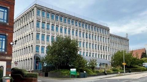 The Civic Centre in Exeter which is a five-storey building with trees in front of it.