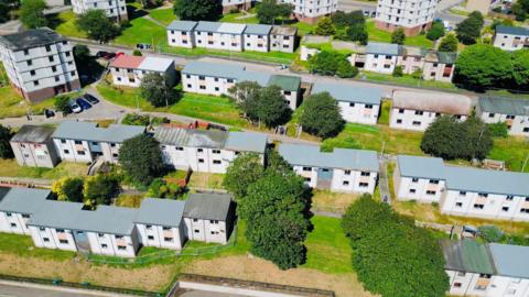 Aerial view of rows of housing in Aberdeen, there are also trees, and cars parked.