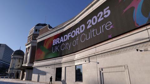 Large vibrant electronic sign shows Bradford's designation for the UK City of Culture set on the facade of the Bradford Live entertainment venue.
