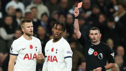 Destiny Udogie of Tottenham Hotspur looks dejected after being shown a red card