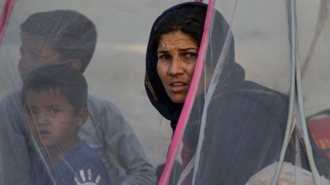 Displaced Afghans sit in a tent at a makeshift IDP camp in Share-e-Naw park in Kabul