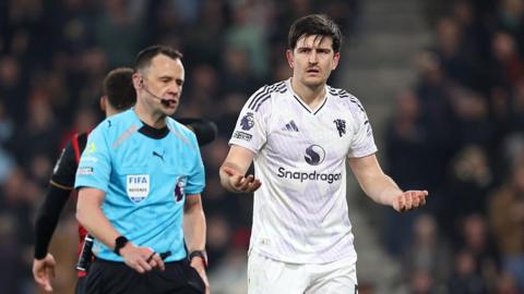 Harry Maguire gestures after receiving a red card