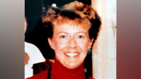 An old photo of Janice Cartwright-Gilbert is wearing a red polo-neck jumper.