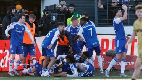 Macclesfield players celebrate scoring against Palace